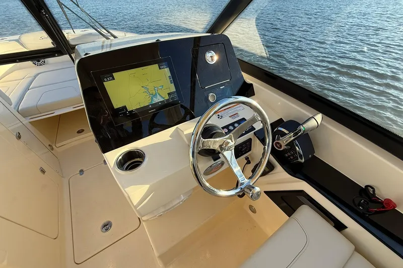 Slide: The Image of 2026 Scout 277 Dorado boat dashboard with navigation screen and steering wheel. - 16