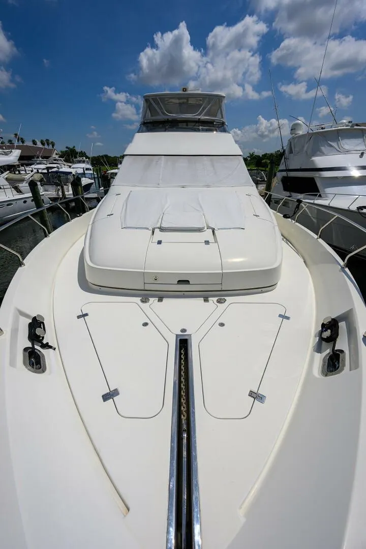 Slide: The Image of 2005 Marquis 65 MY yacht, docked, under a bright blue sky with clouds. - 48