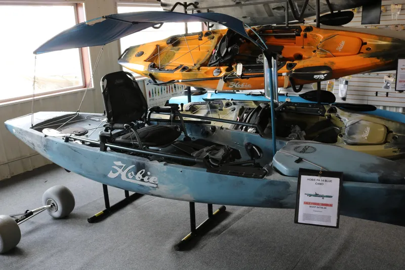 The Image of 2023 Hobie Mirage Pro Angler 14 kayak displayed indoors with accessories. - 0