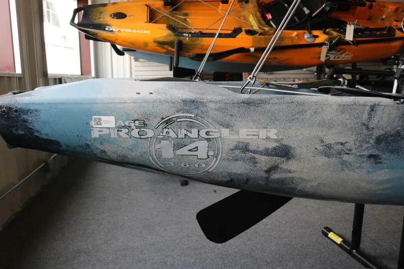 Slide: The Image of 2023 Hobie Mirage Pro Angler 14 kayak displayed indoors, showcasing sleek design and branding. - 4