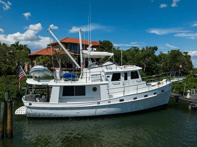 Slide: The Image of 2013 Krogen 44' AE Widebody yacht docked by a waterfront home. - 29