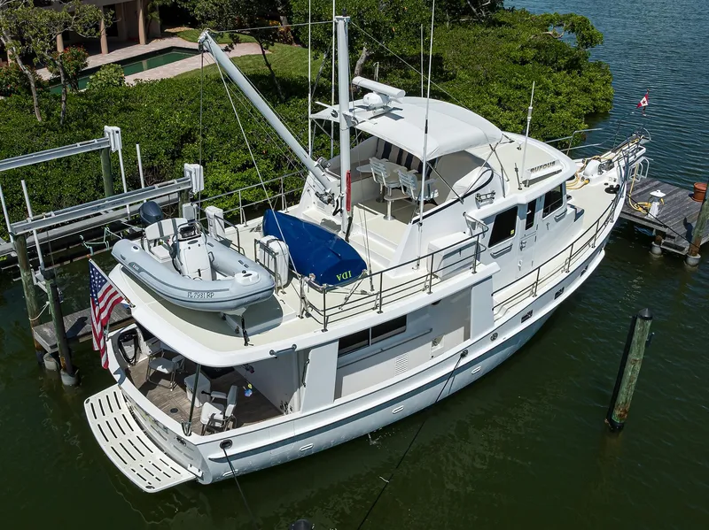 Slide: The Image of 2013 Krogen 44' AE Widebody yacht docked with tender and American flag. - 30