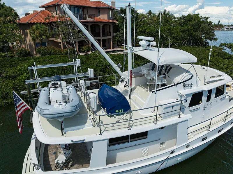Slide: The Image of 2013 Krogen 44' AE Widebody yacht with dinghy, docked near waterfront home. - 36