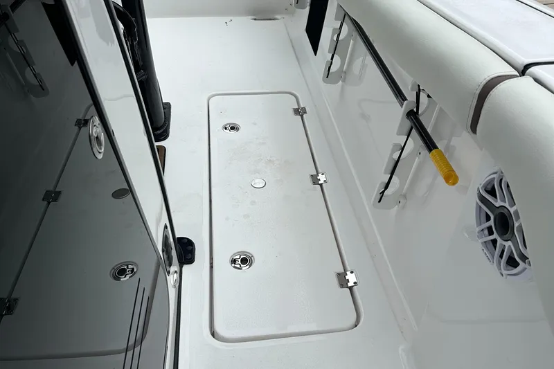 Slide: The Image of 2025 Tidewater 256 LXF boat interior with storage compartment and rod holder. - 10