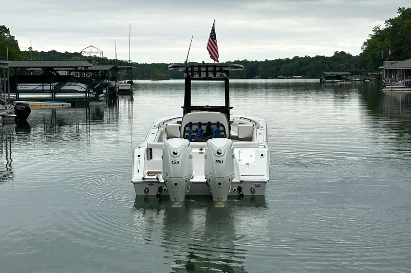 Slide: The Image of 2025 Tidewater 256 LXF boat with dual engines on a calm lake. - 13