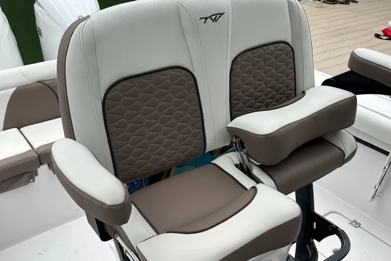 Slide: The Image of 2025 Tidewater 256 LXF boat seat with brown and white upholstery, featuring armrests. - 17
