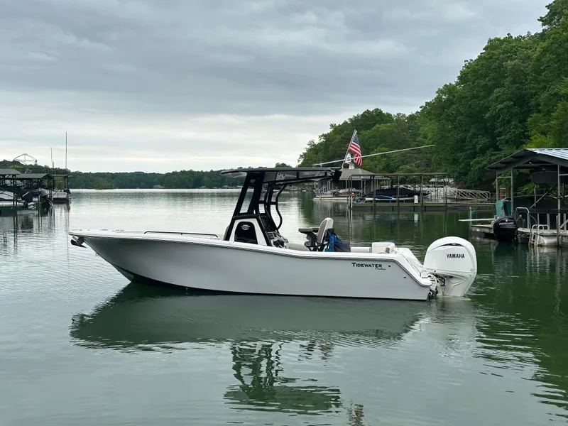 Slide: The Image of 2025 Tidewater 256 LXF boat on calm lake with overcast sky. - 2