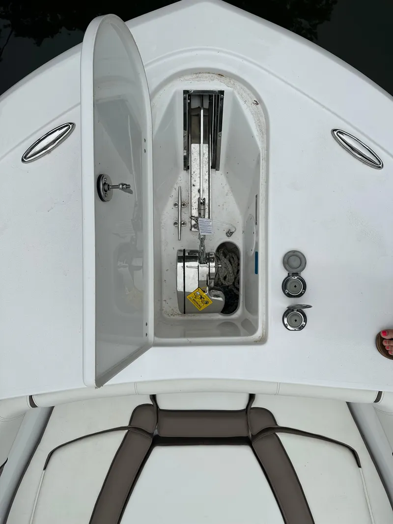 Slide: The Image of 2025 Tidewater 256 LXF boat anchor compartment with open hatch and visible winch. - 3