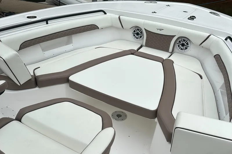 Slide: The Image of 2025 Tidewater 256 LXF boat interior with cushioned seating and built-in speakers. - 7