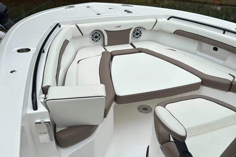 Slide: The Image of 2025 Tidewater 256 LXF boat interior with cushioned seating and speaker system. - 8