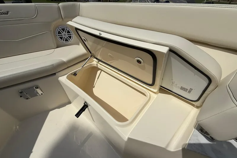 Slide: The Image of 2026 Scout 240 XSF boat interior with open storage compartment and speaker. - 11