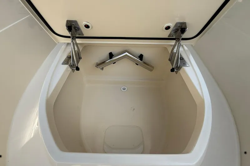 Slide: The Image of Storage compartment of 2026 Scout 240 XSF boat, featuring stainless steel hinges. - 17