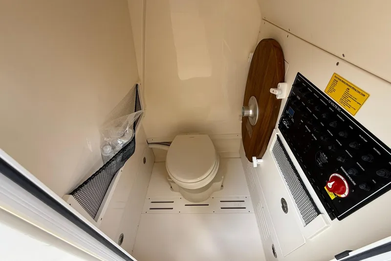 Slide: The Image of 2026 Scout 240 XSF boat interior with compact marine toilet and control panel. - 18