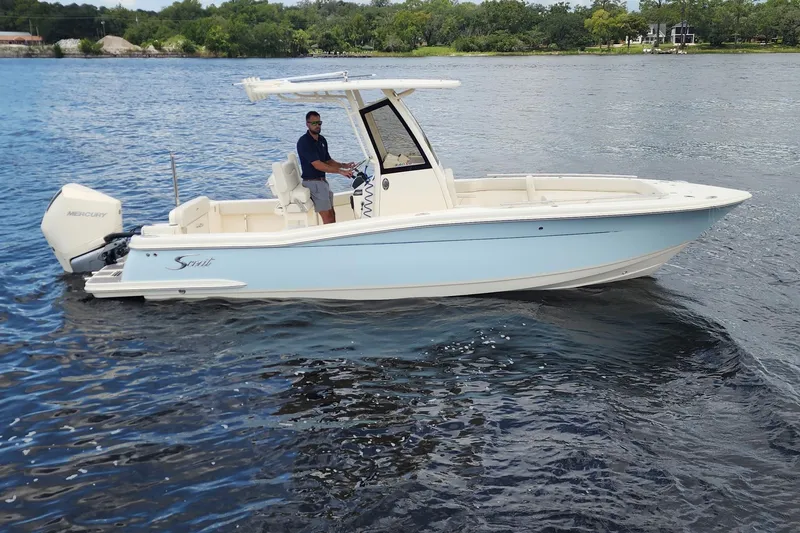 Slide: The Image of 2026 Scout 240 XSF boat on water with Mercury engine, piloted by a person. - 2