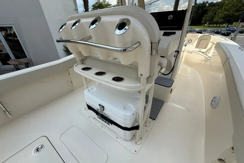 Slide: The Image of 2026 Scout 240 XSF boat interior with rod holders and cooler storage. - 23