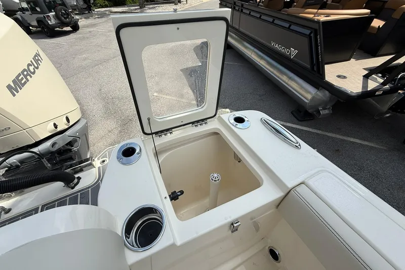 Slide: The Image of 2026 Scout 240 XSF boat with open storage compartment and Mercury engine. - 28