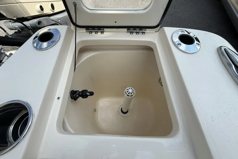 Slide: The Image of Livewell compartment on 2026 Scout 240 XSF boat, featuring rod holders and drainage system. - 29