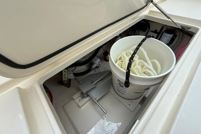 Slide: The Image of Open storage compartment in 2026 Scout 240 XSF boat with bucket and rope. - 30