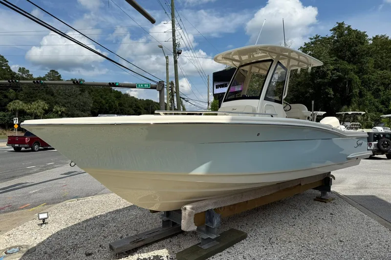 Slide: The Image of 2026 Scout 240 XSF boat displayed outdoors on a stand, under a partly cloudy sky. - 8