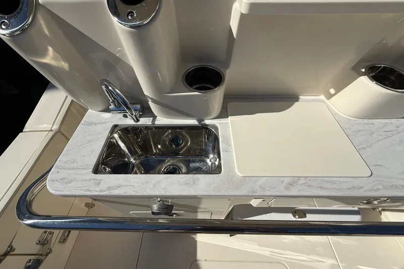 Slide: The Image of 2026 Scout 260 LXF boat sink and cutting board on deck. - 27