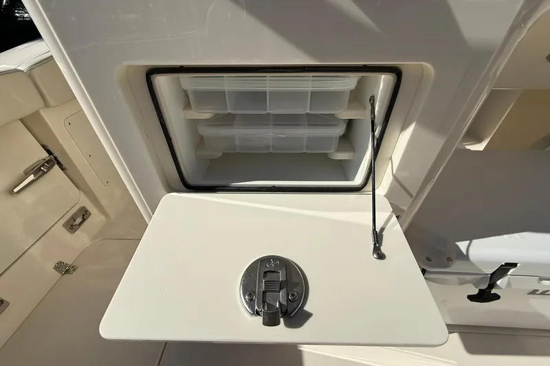 Slide: The Image of 2026 Scout 260 LXF boat storage compartment with open hatch and organized interior. - 29