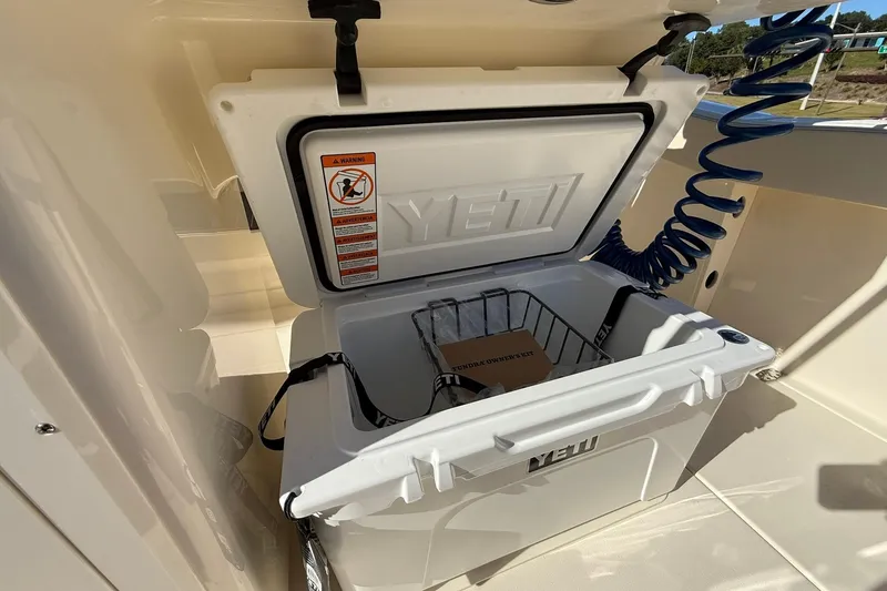 Slide: The Image of Open YETI cooler on 2026 Scout 260 LXF boat, showing interior storage. - 30