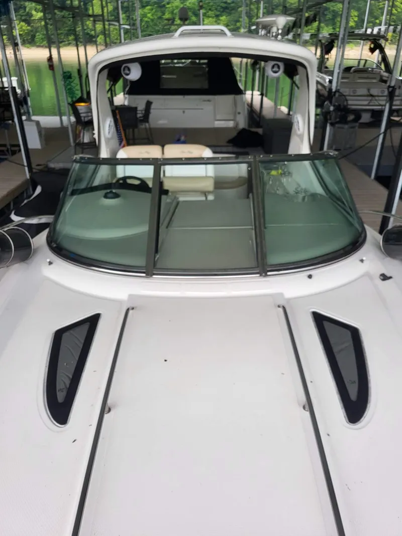 Slide: The Image of 2009 Sea Ray 310 Sundancer boat docked, featuring sleek design and spacious cockpit. - 13