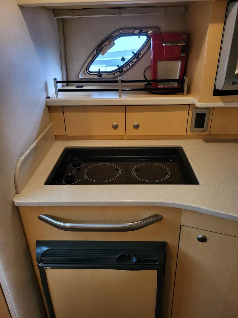Slide: The Image of Compact kitchen area in 2009 Sea Ray 310 Sundancer yacht with stove and window. - 17