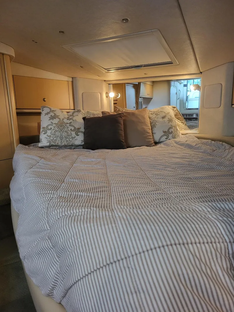 Slide: The Image of Cozy cabin interior of 2009 Sea Ray 310 Sundancer with comfortable bedding and ambient lighting. - 18
