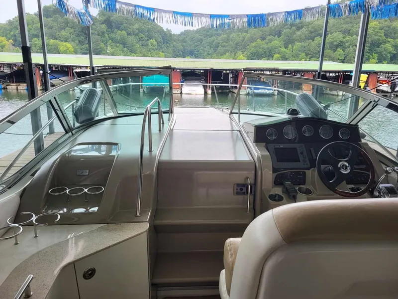 Slide: The Image of 2009 Sea Ray 310 Sundancer cockpit with steering wheel, dashboard, and marina view. - 3