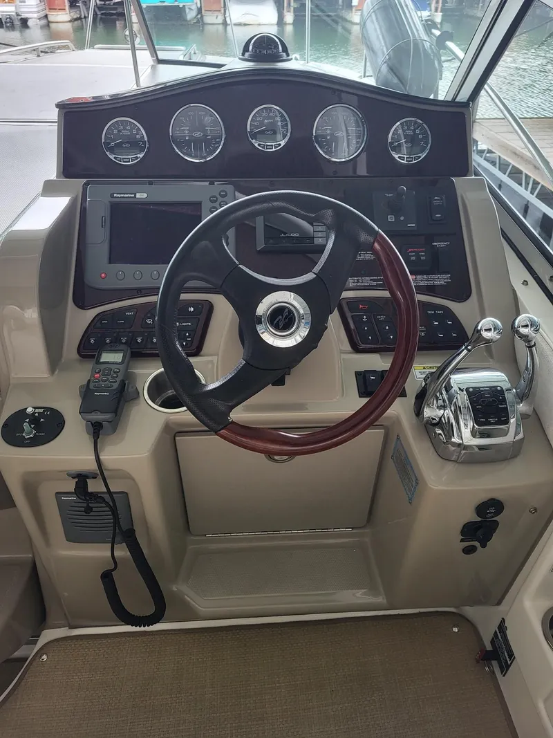 Slide: The Image of 2009 Sea Ray 310 Sundancer helm with steering wheel, gauges, and controls. - 4