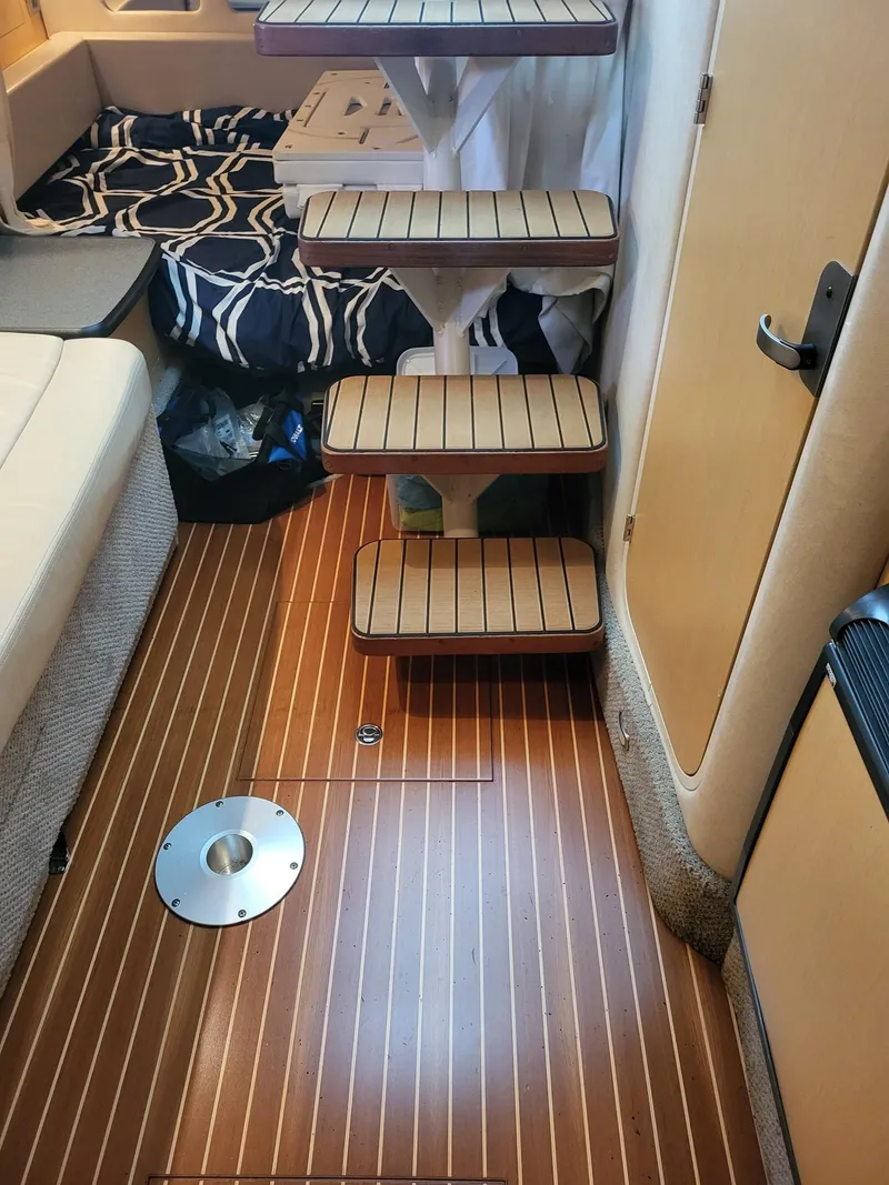 Slide: The Image of Interior of a 2009 Sea Ray 310 Sundancer with wooden flooring and compact stairs. - 7
