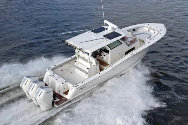 Slide: The Image of 2026 Scout 357 LXF boat cruising on a serene lake under a partly cloudy sky. - 2