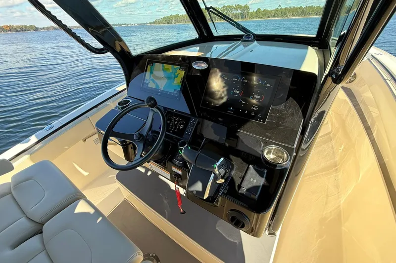 Slide: The Image of 2026 Scout 357 LXF boat cockpit with advanced navigation and control systems on a sunny day. - 25