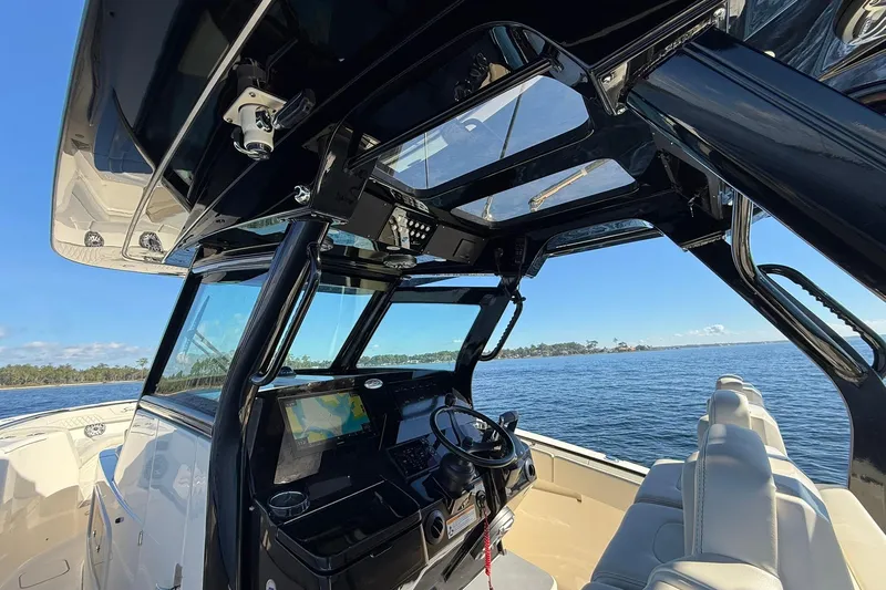 Slide: The Image of 2026 Scout 357 LXF boat interior with advanced navigation system and luxurious seating on open water. - 28