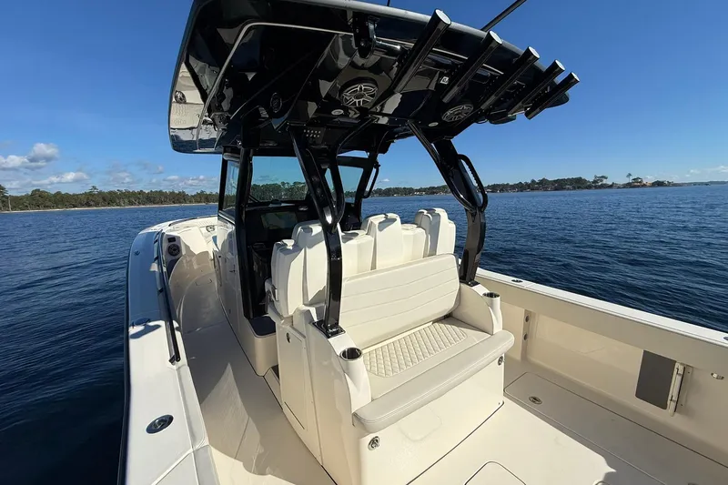 Slide: The Image of 2026 Scout 357 LXF boat interior with seating and rod holders on a sunny day. - 29