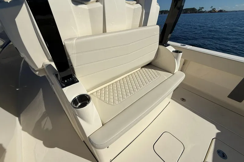 Slide: The Image of 2026 Scout 357 LXF boat seat with cup holders, on a sunny day by the water. - 30