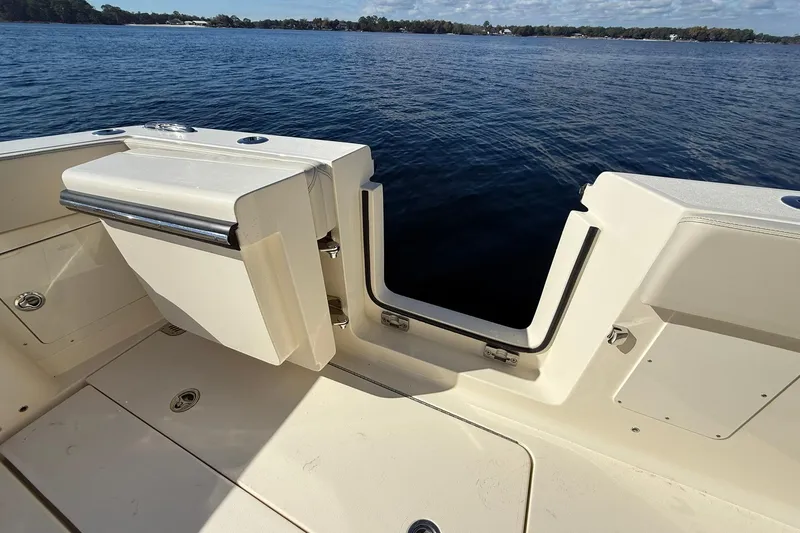 Slide: The Image of 2026 Scout 357 LXF boat deck with open transom door, overlooking calm water. - 38