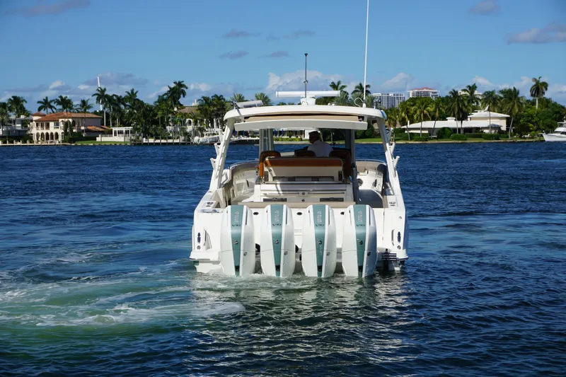 Slide: The Image of 2026 Boston Whaler 420 Outrage cruising on open sea with four engines. - 10