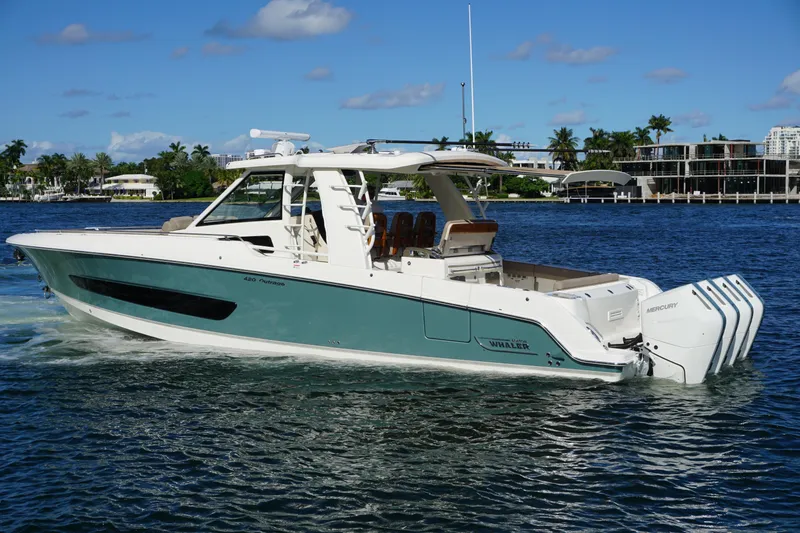 Slide: The Image of 2026 Boston Whaler 420 Outrage cruising on ocean near city skyline. - 14