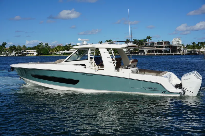 Slide: The Image of 2026 Boston Whaler 420 Outrage cruising near a city skyline on a sunny day. - 15