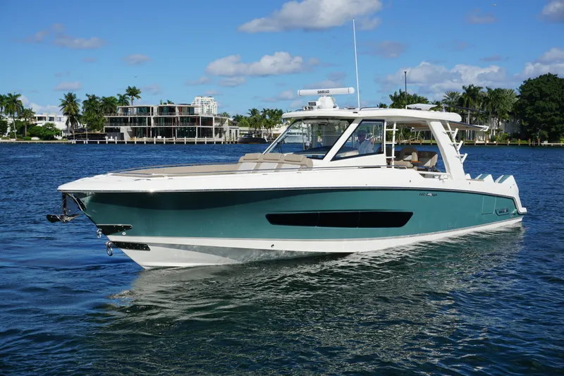 Slide: The Image of 2026 Boston Whaler 420 Outrage cruising on blue ocean near city skyline. - 16