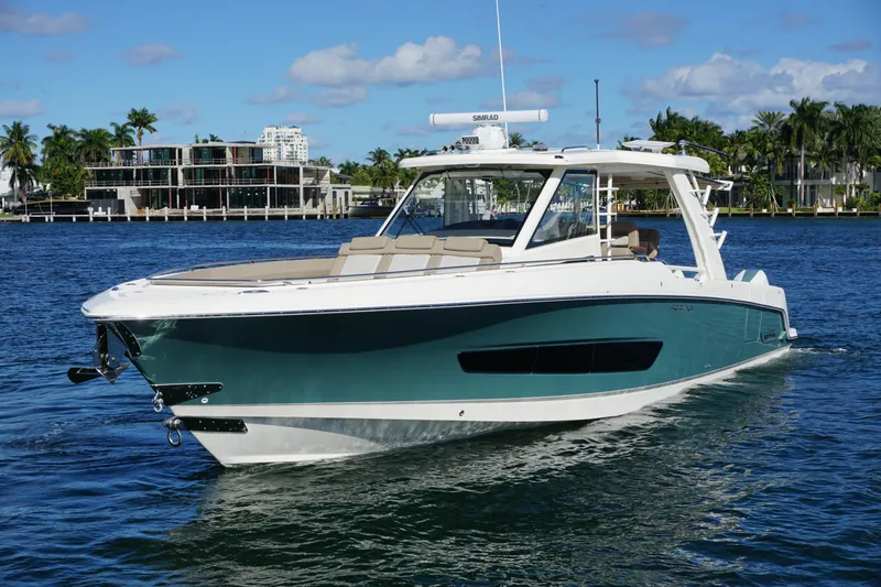 Slide: The Image of 2026 Boston Whaler 420 Outrage cruising on open water, city skyline in background. - 18