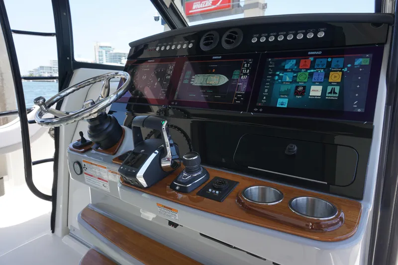 Slide: The Image of 2026 Boston Whaler 420 Outrage anchor compartment with open hatch, on calm water. - 30