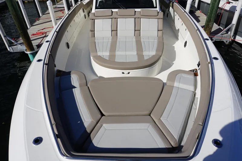 Slide: The Image of 2026 Boston Whaler 420 Outrage boat with open storage compartment, luxurious seating, and ocean backdrop. - 34