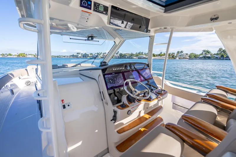 Slide: The Image of 2026 Boston Whaler 420 Outrage helm with advanced navigation, luxurious seating, and ocean view. - 42