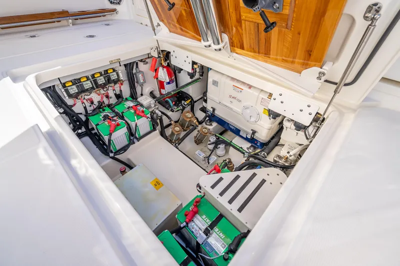 Slide: The Image of Engine compartment of 2026 Boston Whaler 420 Outrage, showcasing batteries and equipment. - 52
