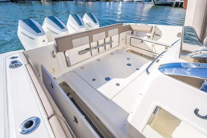 Slide: The Image of 2026 Boston Whaler 420 Outrage boat deck with Mercury engines, docked on calm water. - 55