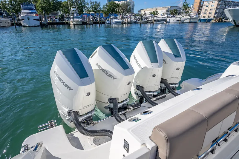 Slide: The Image of 2026 Boston Whaler 420 Outrage with four Mercury outboard engines docked in marina. - 60