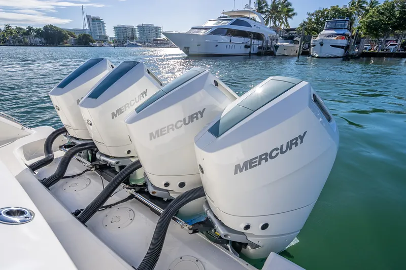 Slide: The Image of 2026 Boston Whaler 420 Outrage with four Mercury outboard engines docked in marina. - 62